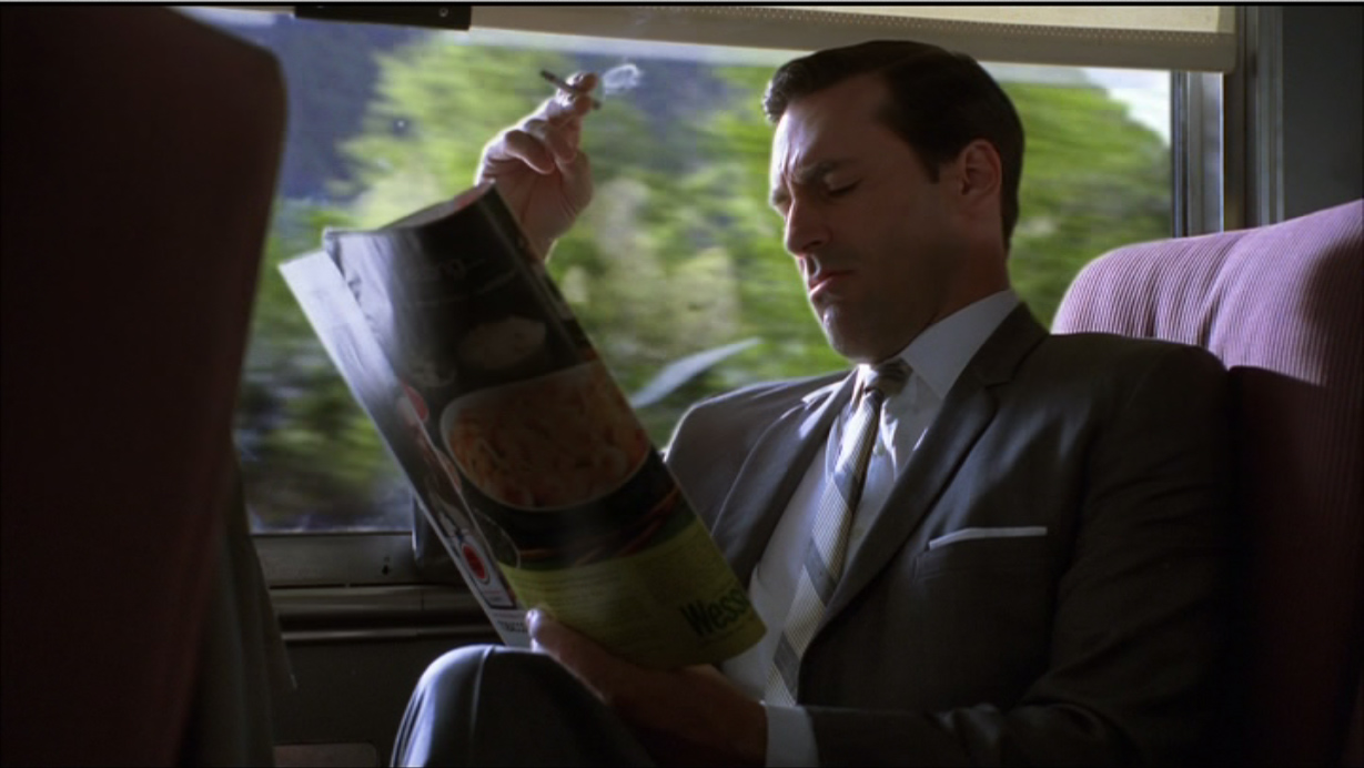 Don Draper (Jon Hamm) lit dans le train la publicité Lemon pour Volkswagen