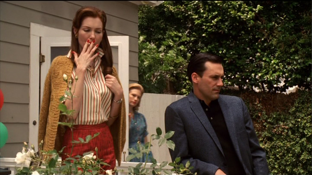 Betty Draper (January Jones) sort de la cuisine pour demander à Don d’aller chercher le gâteau d’anniversaire à la pâtisserie